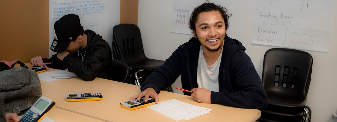 Student in class using a calculator